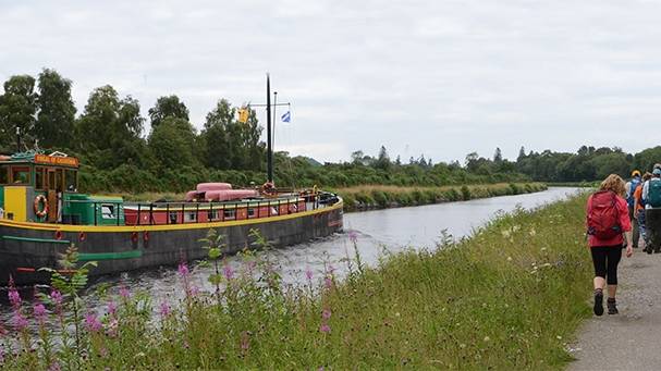 Walkers on the towpath to Inverness with the comfortable barge Fingal