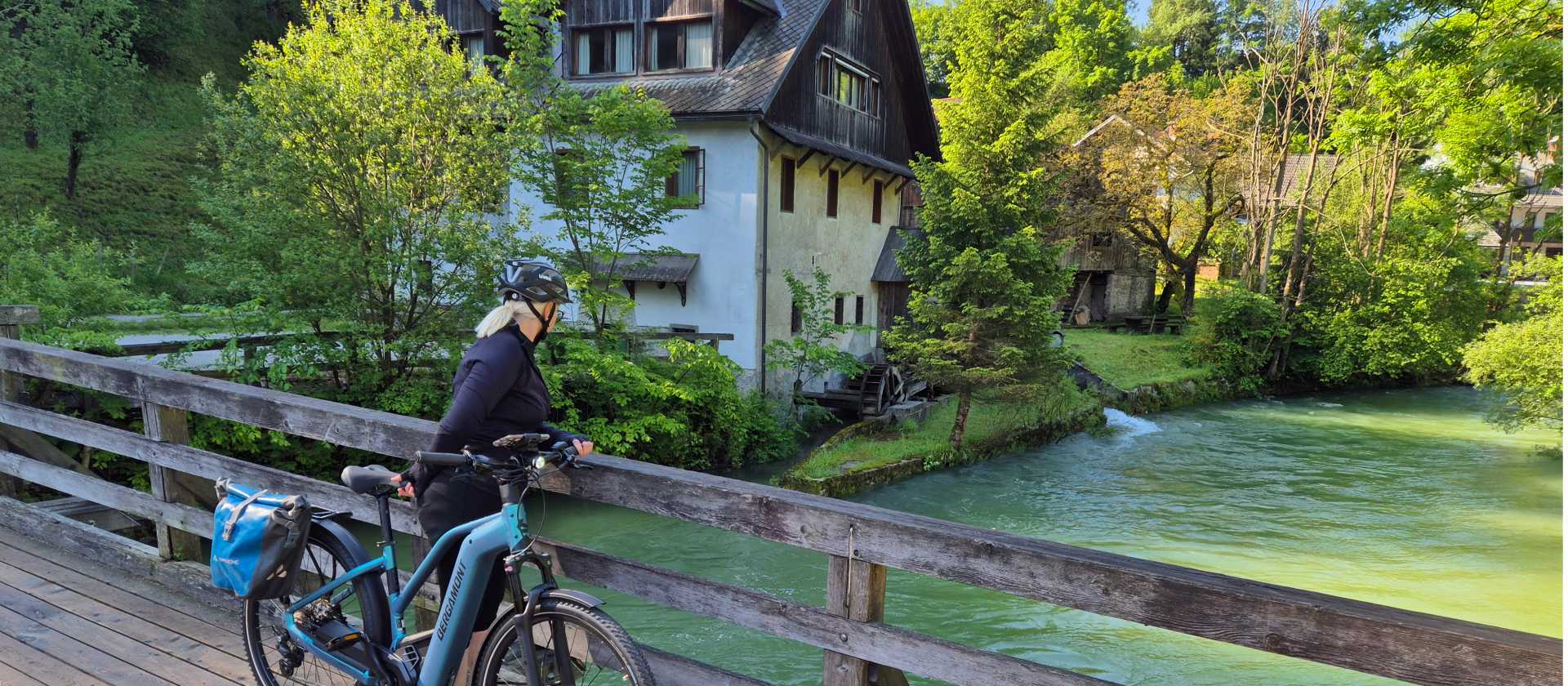 Cycling beside one of Slovenia’s clear alpine waterways, surrounded by the Julian Alps