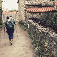 Pilgrims hiking through small village on the Camino | @timcharody