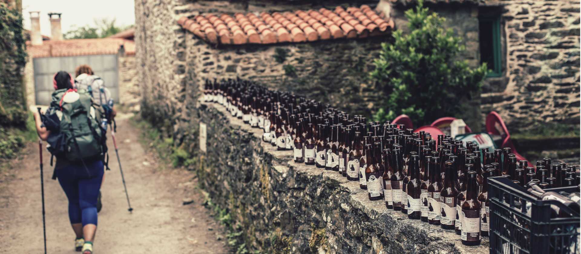 Pilgrims hiking through small village on the Camino | @timcharody
