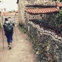 Pilgrims hiking through small village on the Camino | @timcharody