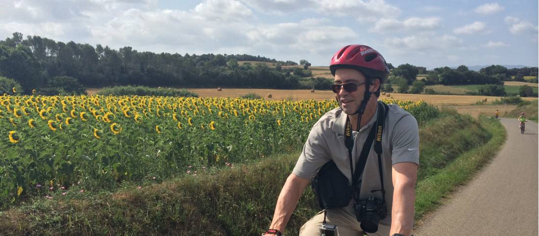 Cyclist passing sunflowers on a rural road on a self guided cycle trip in Catalonia |  <i>Kate Baker</i>