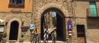 Family group cycling in a village in Catalonia on a self guided holiday | Kate Baker