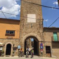 Family group cycling in a village in Catalonia on a self guided holiday | Kate Baker