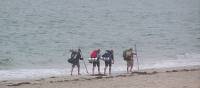 Pilgrims walking along the beach to Finisterre