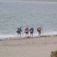 Pilgrims walking along the beach to Finisterre