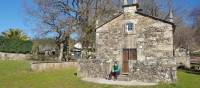 Pilgrim resting at a chapel on the Camino Sanabres trail to Santiago