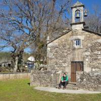Pilgrim resting at a chapel on the Camino Sanabres trail to Santiago