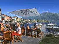 Cyclists taking a break at a cafe by Lake Maggiore in the Ticino region