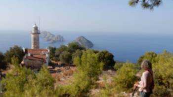 Hiker enjoying the view of Cape Gelidonia lighthouse and the 'Five Islands'