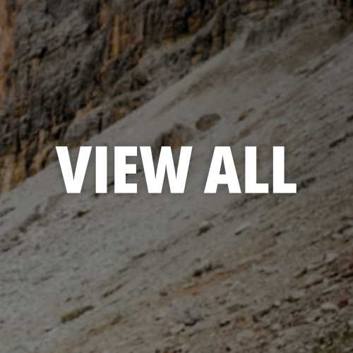 Mountain scree slope below a weathered rock cliff face, alpine terrain.