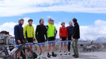 Happy cyclist faces after making it to the top of the Col