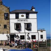 Walkers celebrating the end of the Coast to Coast in Robin Hood's Bay | John Millen