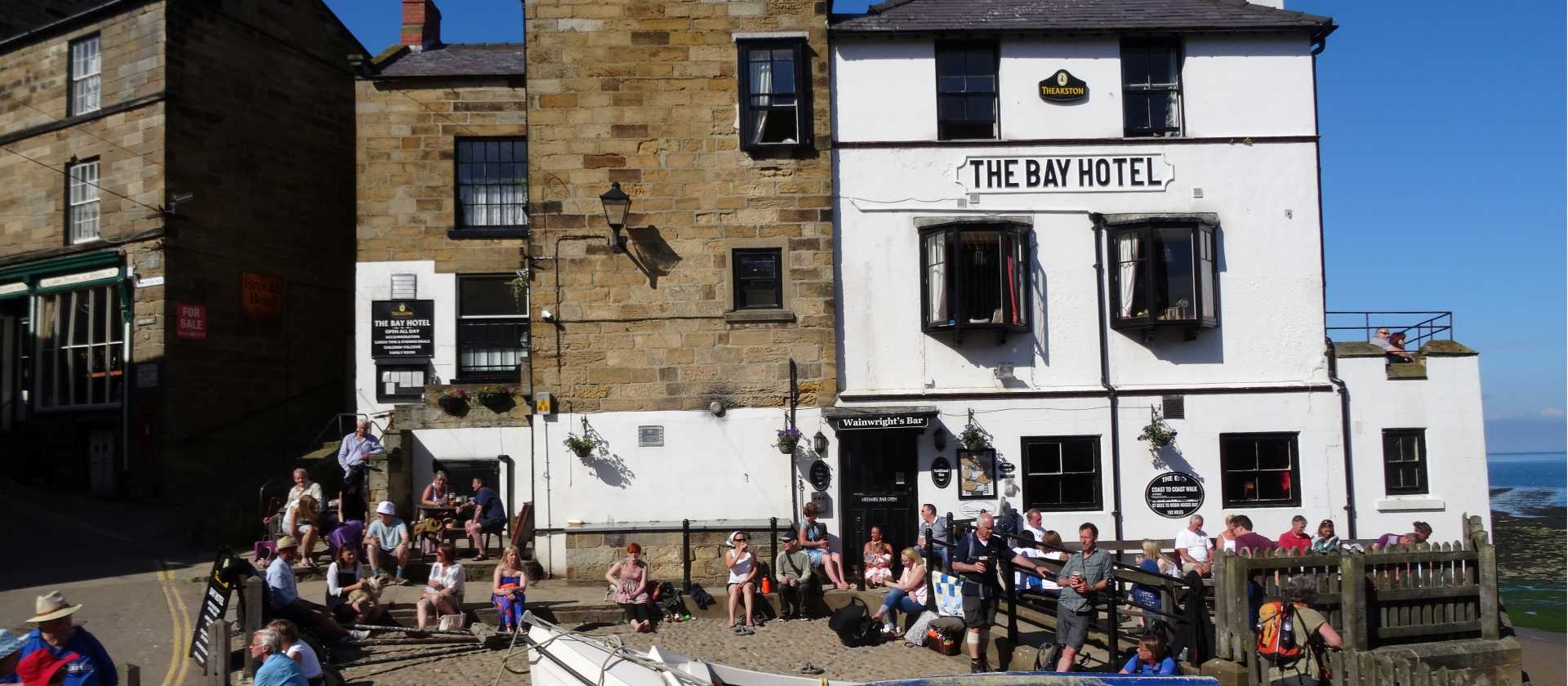 Walkers celebrating the end of the Coast to Coast in Robin Hood's Bay | John Millen