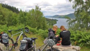 Cyclists overlooking Great Glen & Loch Ness in Scotland