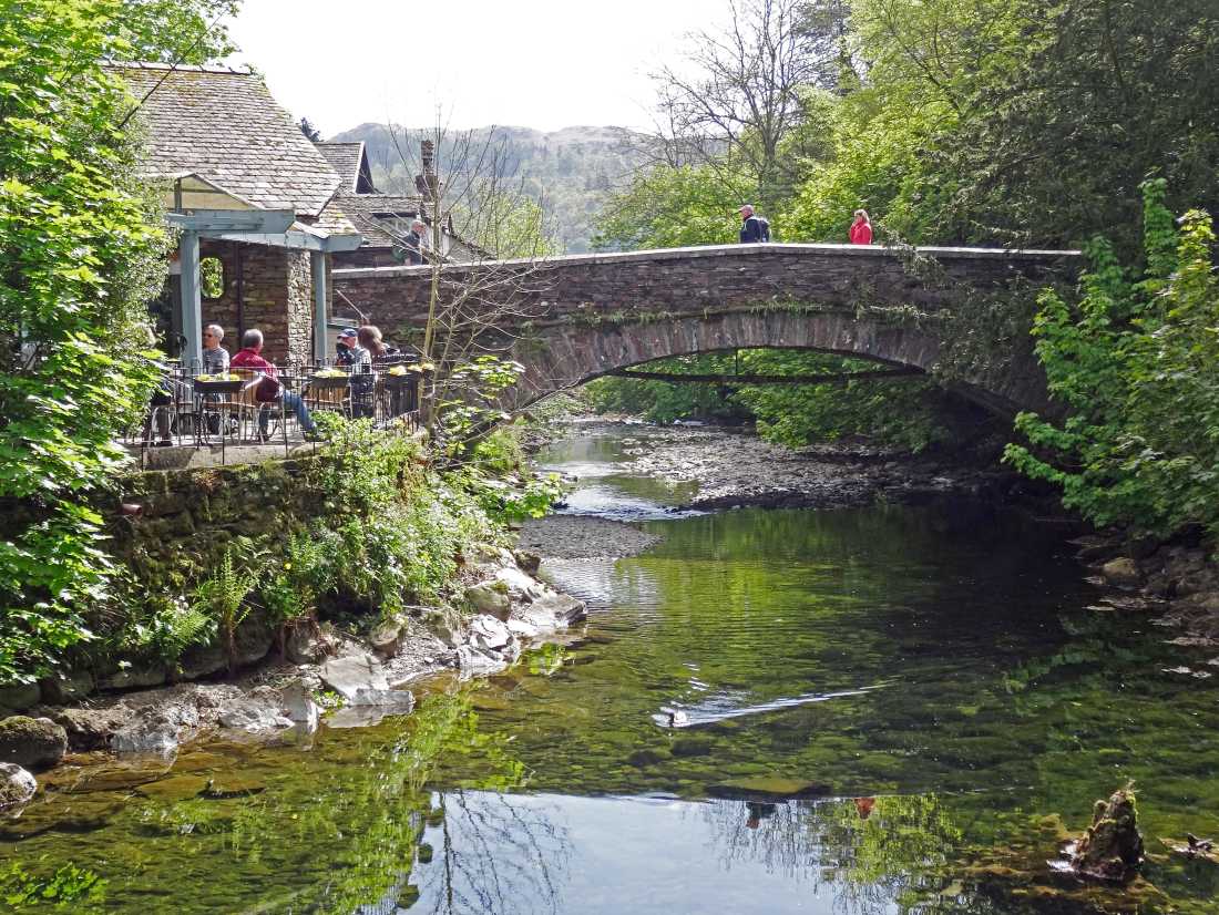 Walkers taking a rest at Grasmere Bridge on the Coast to Coast trail |  John Millen