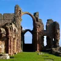 Expansive Medieval monastery ruins with ornately sculpted stonework, in tidal island setting. | A Turton