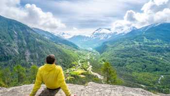 A hiker taking in the sweeping alpine views of Écrins National Par
