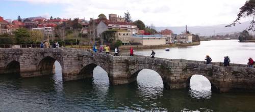 Pilgrims crossing a bridge along the Portuguese Way