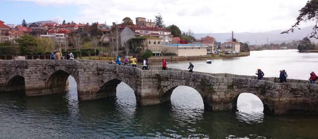 Pilgrims crossing a bridge along the Portuguese Way