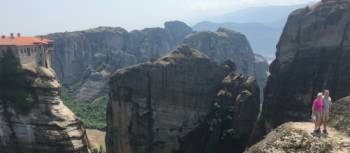 Hikers above a precipitous ridge overlooking Varlaam Monastery in Meteora | Kate Baker