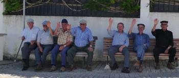 Cycling by old men resting on park benches in the Alentejo