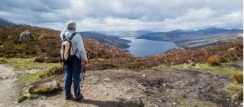 A walker admiring the view on the summit of Ben A an on the Rob Roy Way. | Kenny Lam